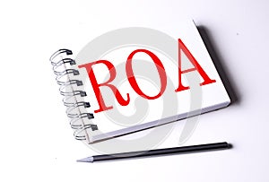 ROA word on notebook on white background photo
