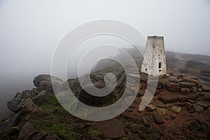 The Roaches trig point on a very foggy and gloomy December morning. Peak District, UK