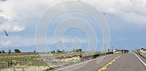 On the road again in Colorado with rocky mountains in the horizon