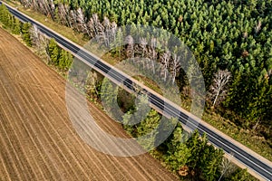 Road along the forest and field top view from a drone.