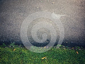 Road along the green lawn asphalt.