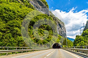 Road among Alps mountains with a toonel in a rock, Klosters-Serneus, Davos, Graubuenden Switzerland