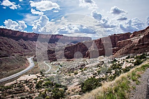 Winding road through Arches National Park in Utah on a sunny day with clouds in sky
