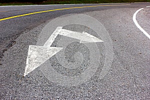 Road arrow direction sign on the asphalt road, transportation