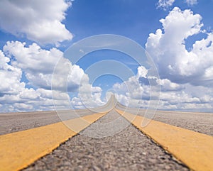 Road asphalt to the sky over the clouds