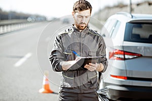 Road assistance worker with documents on the highway