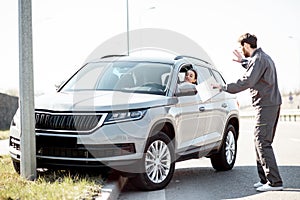 Road assistance worker helping to drive for a young woman