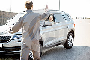 Road assistance worker helping to drive for a young woman