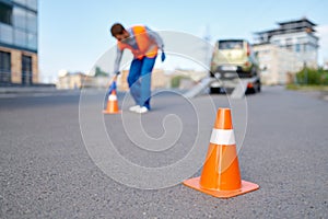 Road assistance worker putting cones near evacuator