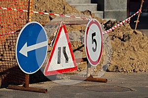 Road atention signs near the trench on the road.