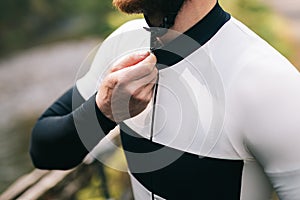 Road bicycle rider in white  jersey on the road in forest