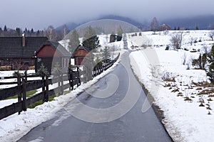 Road in Bieszczady to Wetlina and Solina, Winter day with lot of snow. Buildings in the background