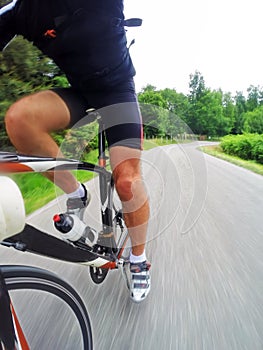 Road bike; male cyclist riding a racing bike downhill