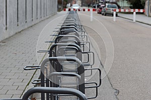 Road block on car-free street with row of enpty bike racks and concrete wall