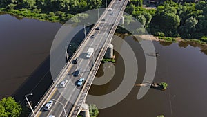 Road bridge with moving cars in sunlight, aerial view.