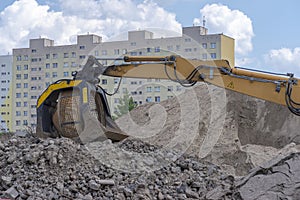 Road building. Heaps of stones and substrate. Visible excavator arm with rotating screen.