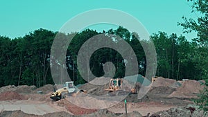 A road bulldozer and a vibratory roller are building a road outside the city, leveling and compacting sand on the road