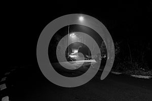 Road in Campos do JordÃÂ£o photographed at night with fog in black and white