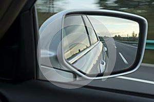Road in car side-view mirror