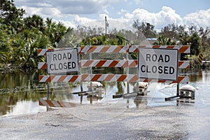 Road closed for roadworks and danger of flooding with warning signs blocking driving of cars