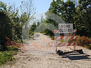 Road closed sign and barricade and trail