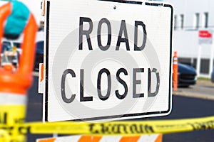 Road closed sign and block in a busy city street.