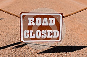 ROAD CLOSED sign hangs from a rope