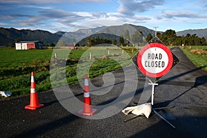 Road closed sign and traffic cones on country road