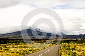 Road and cloudy mountains at Thingvellir National Park in Iceland