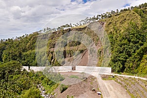 Road with concrete fences on Camiguin Island, Philippines. Protection of the road from rockfalls and landslides.