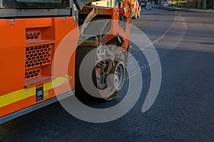 Road construction background. Heavy vibration roller compactor at work paving asphalt, road repairing.