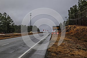 Road construction cones and signs on a rainy day Caution LED sign