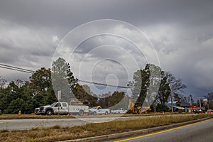Road construction crew work with storm clouds