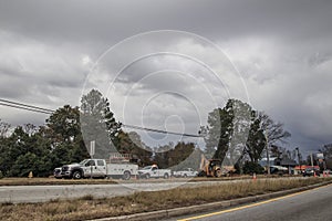 Road construction crew work with storm clouds