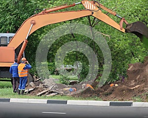 Road construction equipment and workers on the highway.  Tractors, on the road repair site.  Road repair concept