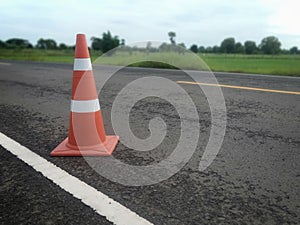 Road construction with a red rubber cone in front