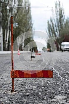 Road construction or repair - laying a new layer of asphalt, marking the level for increased accuracy and warning signs cone