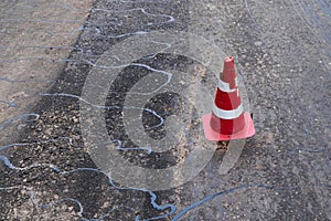 Road construction or repair - laying a new layer of asphalt, marking the level for increased accuracy and warning signs cone