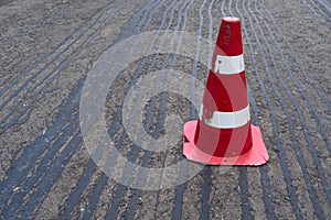 Road construction or repair - laying a new layer of asphalt, marking the level for increased accuracy and warning signs cone