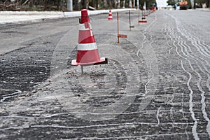 Road construction or repair - laying a new layer of asphalt, marking the level for increased accuracy and warning signs cone