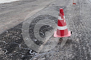 Road construction or repair - laying a new layer of asphalt, marking the level for increased accuracy and warning signs cone