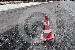 Road construction or repair - laying a new layer of asphalt, marking the level for increased accuracy and warning signs cone