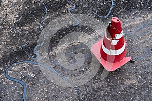 Road construction or repair - laying a new layer of asphalt, marking the level for increased accuracy and warning signs cone