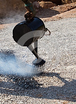 Road construction site with Asian worker making asphalt