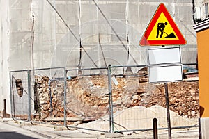 Road construction work and sign at a construction site. Warning sign under construction.