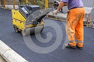 Road construction worker behind construction roller