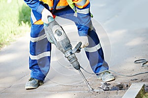 Road construction worker with perforator