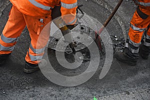 Road construction worker working with pneumatic hammer