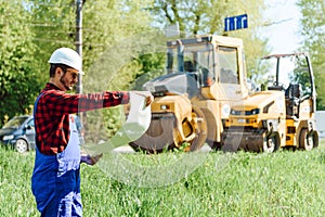 Road construction workers near asphalt paver machine. Road repair. Road service worker near the rink