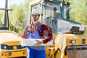 Road construction workers near asphalt paver machine. Road repair. Road service worker near the rink